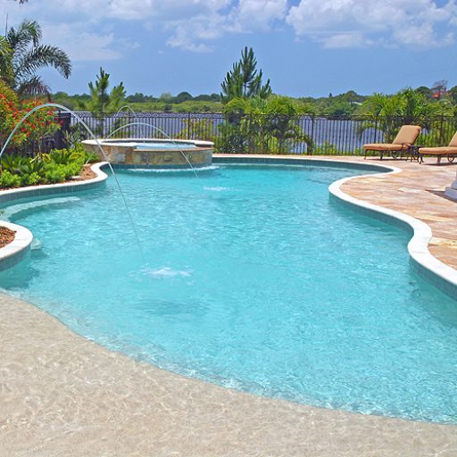 large curved freshwater inground pool with a spa on one end in Clearwater